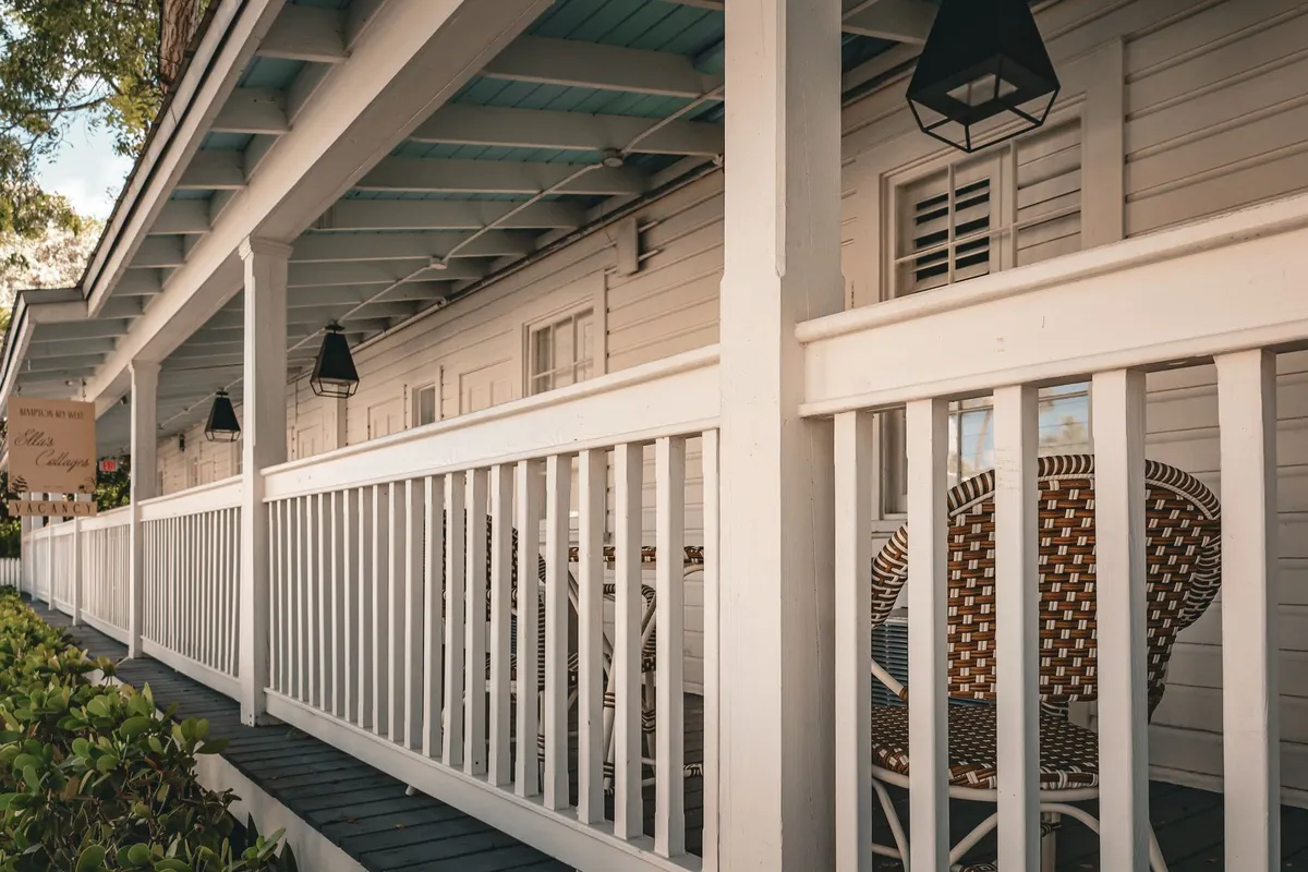 A cozy porch with wicker chairs and lanterns, reflecting a welcoming atmosphere for home buyers.