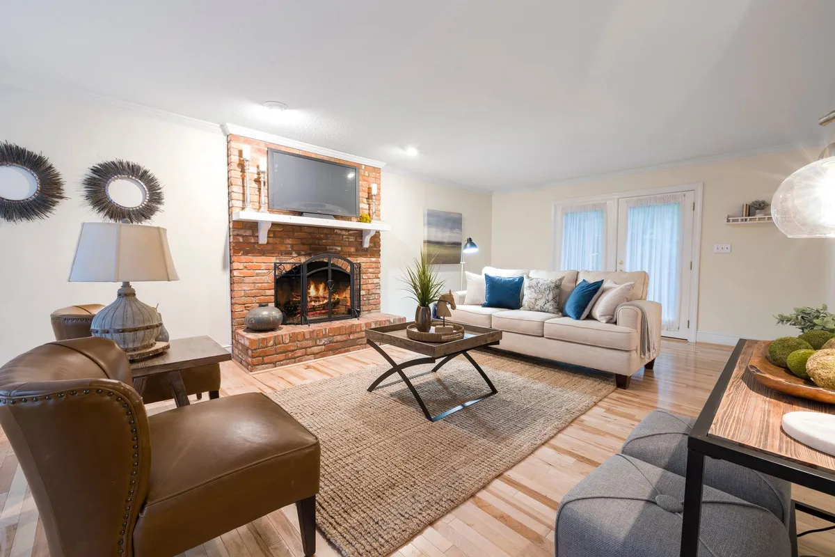 Cozy living room with comfortable seating and a brick fireplace, reflecting a welcoming home atmosphere.