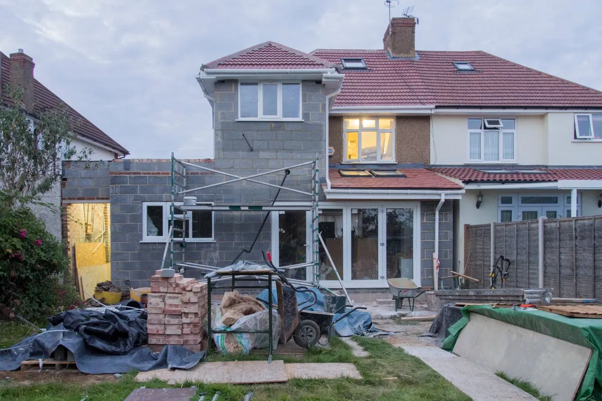A suburban house with scaffolding and construction materials, highlighting the trend of quick sales.